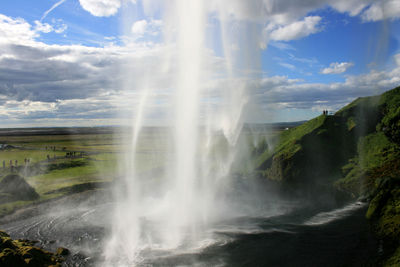 Scenic view of waterfall against sky