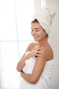 Smiling young woman in bathroom at home