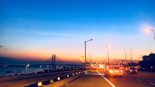 Traffic on road at sunset