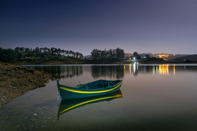 Scenic view of lake against clear sky at night