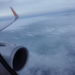 Airplane flying over cloudscape against sky