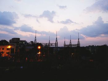 Illuminated cityscape against sky during sunset
