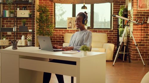 Portrait of young woman using laptop at table