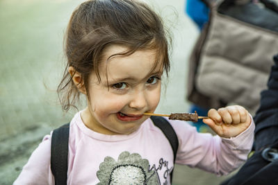 Close-up portrait of cute girl eating food