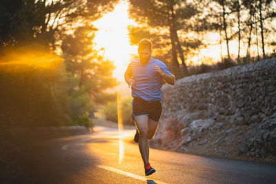 Young man jogging on road