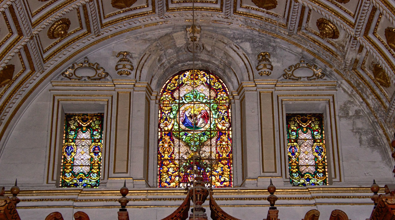 LOW ANGLE VIEW OF ORNATE GLASS BUILDING