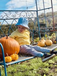 Boy with pumpkins on field