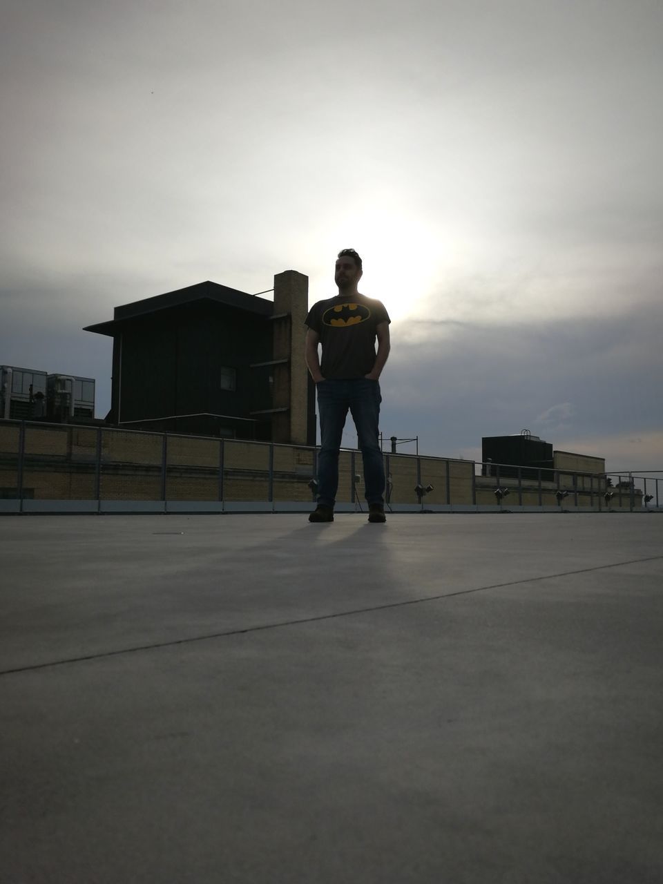 FULL LENGTH OF MAN STANDING ON STREET AGAINST SKY