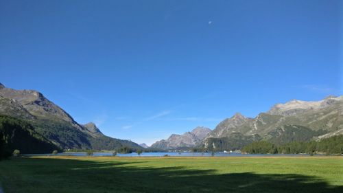 Scenic view of golf course against clear blue sky