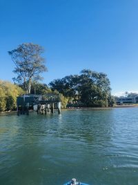 Scenic view of lake against clear blue sky