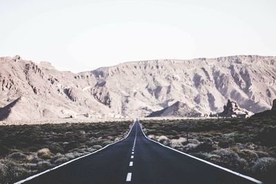 Empty road leading towards mountains