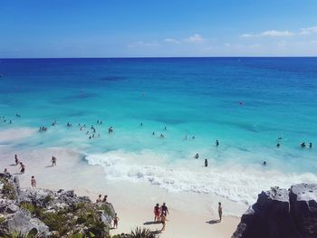 People on beach against blue sky