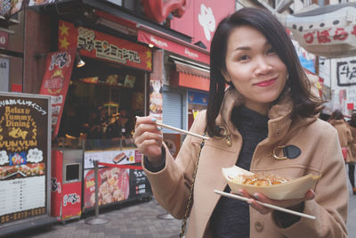 Portrait of woman eating food in restaurant