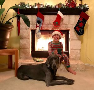 Portrait of smiling woman with dog sitting at home