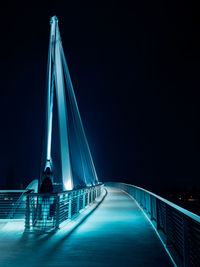 Illuminated bridge against sky at night