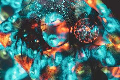 Digital composite image of woman and plasma ball with fiber optics