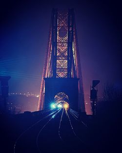 Low angle view of illuminated bridge against sky at night