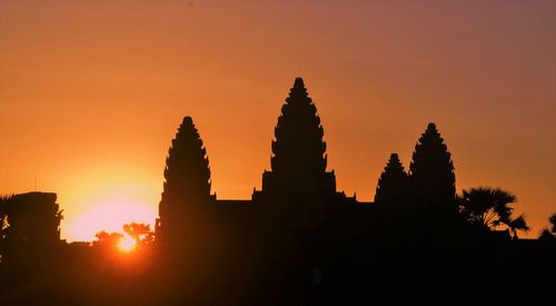 Silhouette angkor wat temple against orange sky