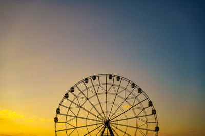 Low angle view of ferris wheel against sky during sunset