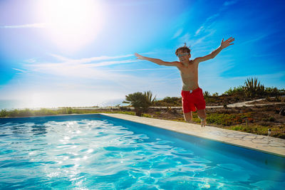 Full length of woman jumping in swimming pool