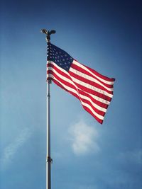 Low angle view of flag against blue sky