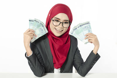 Portrait of young woman wearing mask against white background