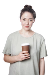 Portrait of smiling young woman standing against white background