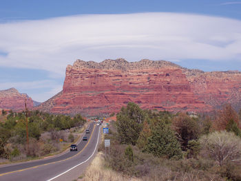 Road leading towards mountains against sky