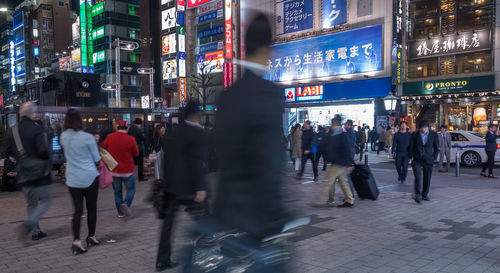 People walking on city street at night