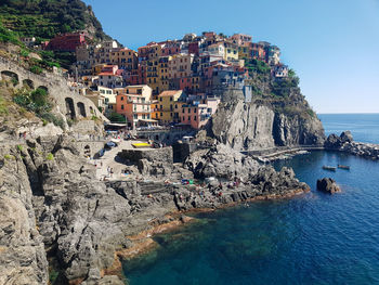 Aerial view of buildings by sea against sky