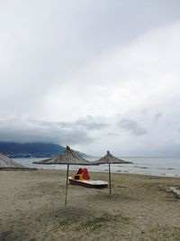 Lifeguard hut on beach against sky