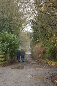 Rear view of woman walking on footpath