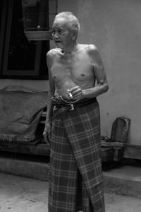 A black and white photo of an old man smoking a cigarette.