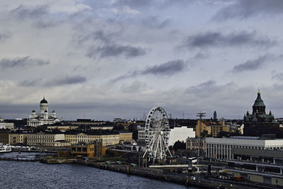 View of buildings at waterfront against cloudy sky