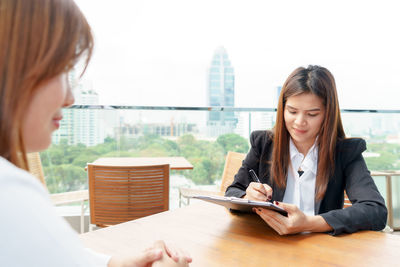 Young woman with text on table in city