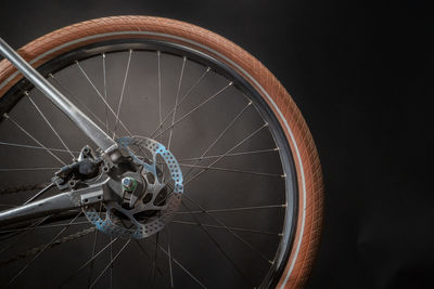 Close-up of bicycle wheel against black background