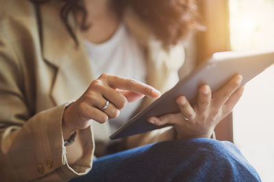 Midsection of woman using digital tablet