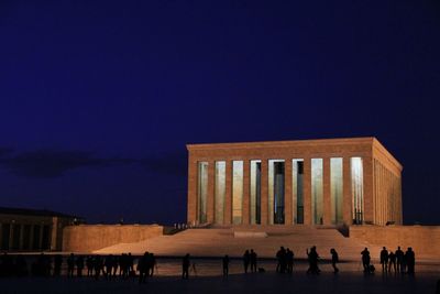 Group of people in front of built structure at night