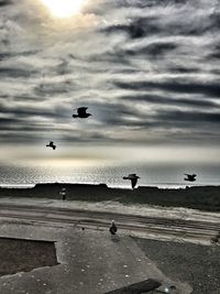 Boats in sea against cloudy sky