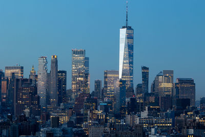 Illuminated cityscape against clear sky