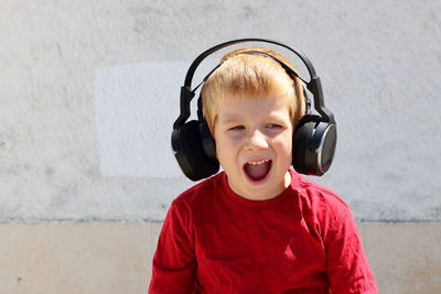 Portrait of boy standing against wall