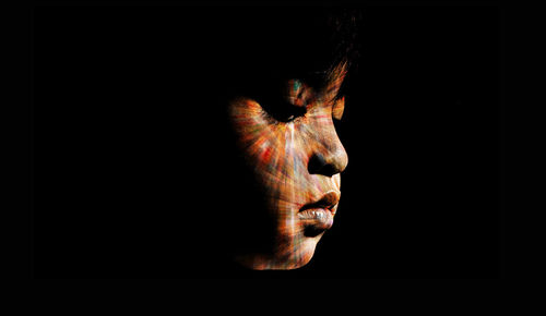 Close-up of boy face against black background