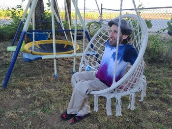 Full length of woman sitting on chair in playground