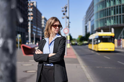 Portrait of young woman standing in city