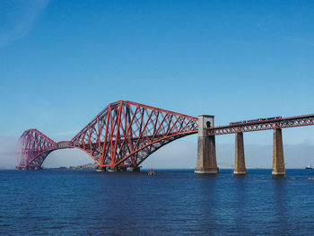 Bridge over sea against blue sky