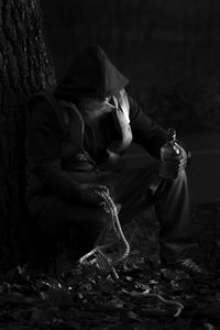 Woman sitting on tree at night