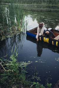 Woman in a boat reaches for water