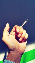 Close-up of hand holding cigarette