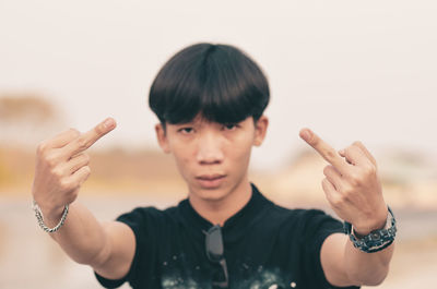 Portrait of boy gesturing while standing outdoors