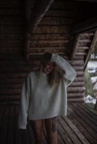 Young woman standing against wall